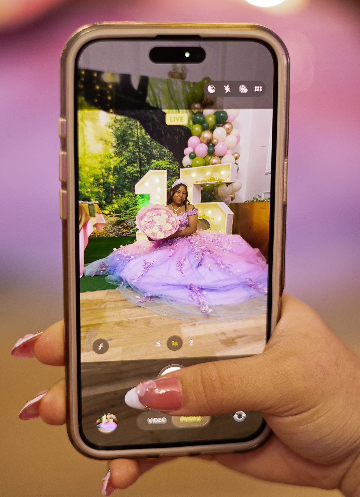 Guest filming the quinceañera on a phone